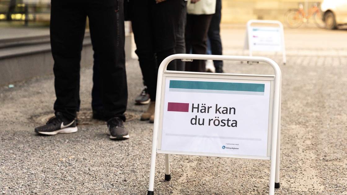 Kö till en vallokal. En skylt där det står Här kan du rösta.