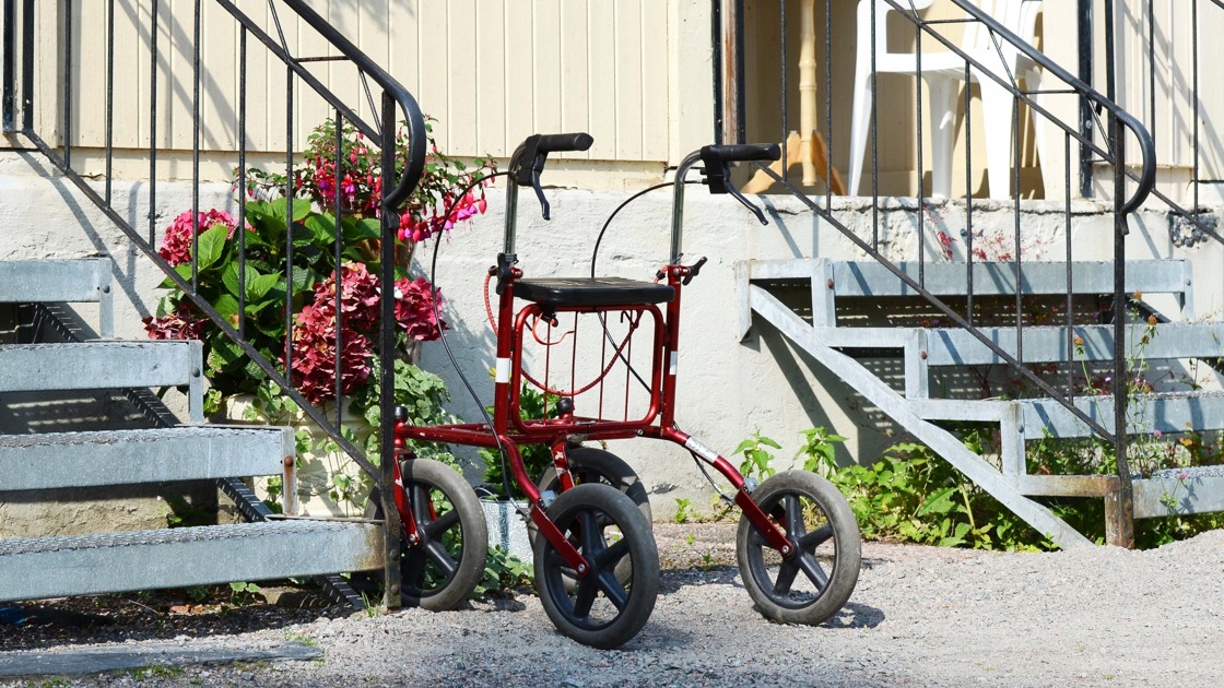 Rullator parkerad framför en husentré.