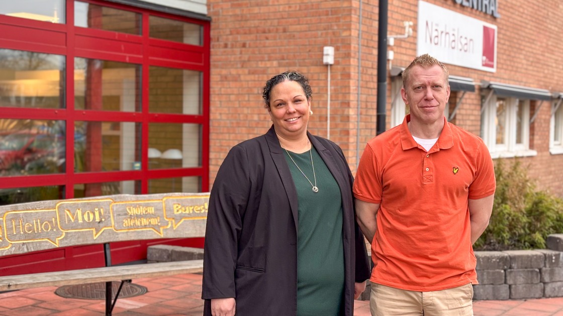 En man och en kvinna står framför en byggnad.