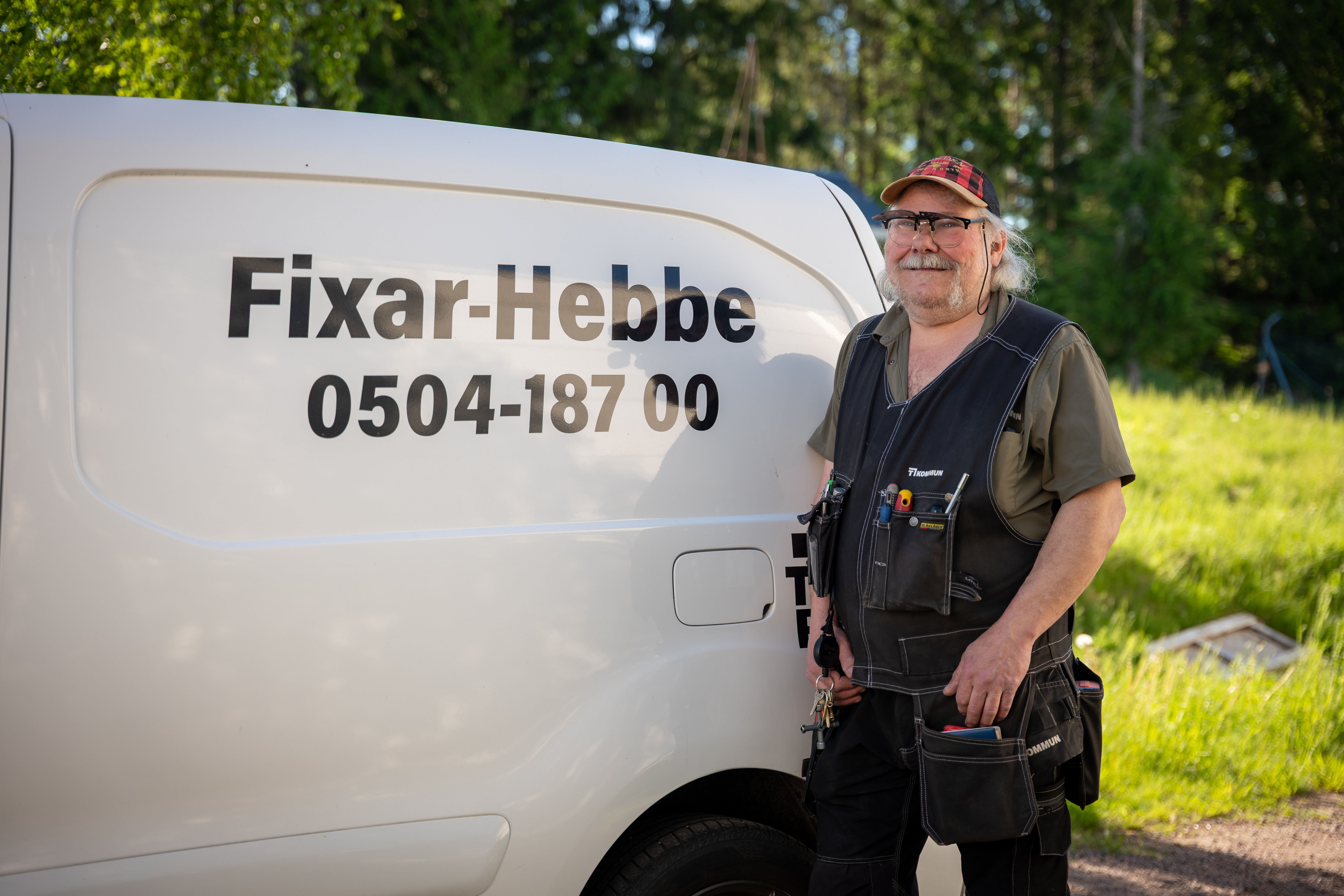 En man som står bredvid en vit skåpbil.