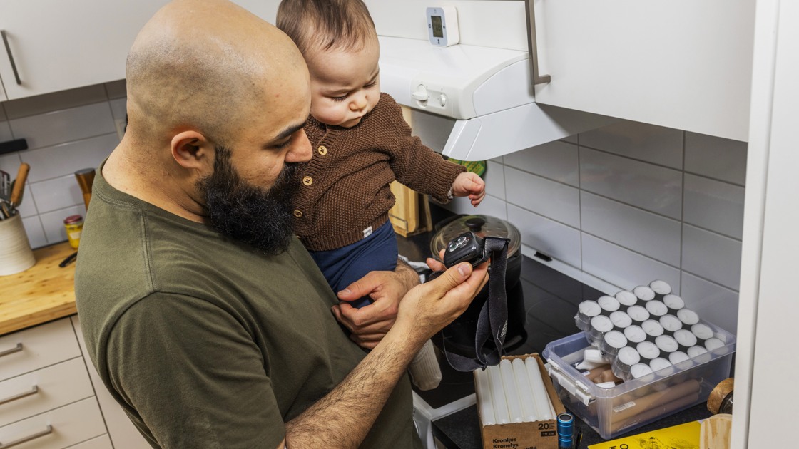 Man med barn på armen som förbereder ett lager för att ha god hemberedskap.