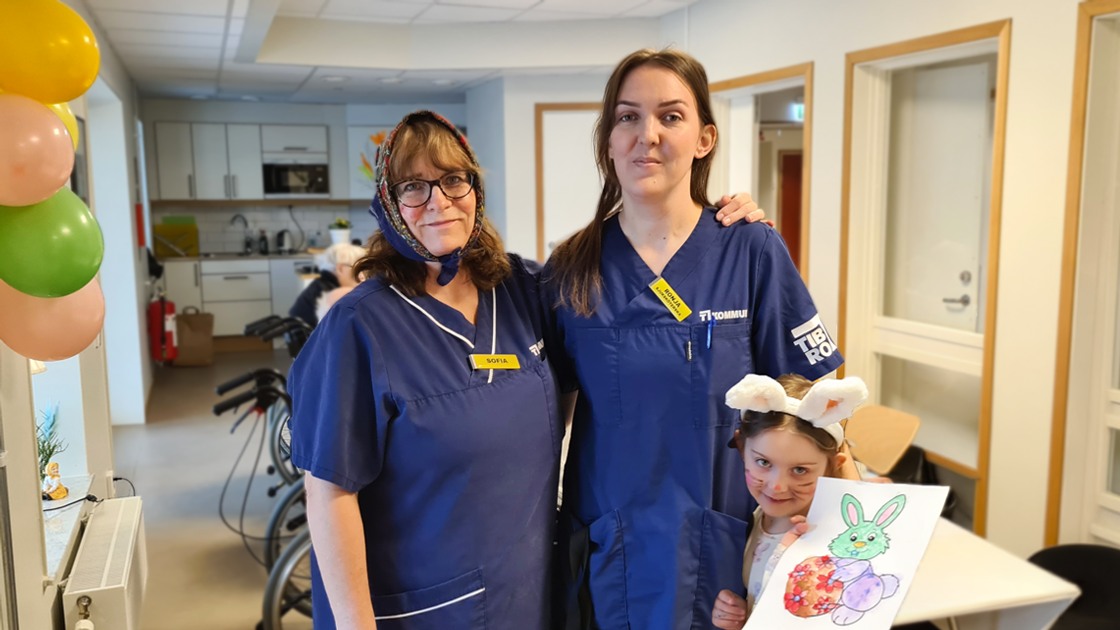 Bilden visar undersköterska Sofia Thorell och sjuksköterska Ronja Eineson, vilka tog initiativet till påskpysslet. På bilden syns även Nora Stark visa sin teckning.