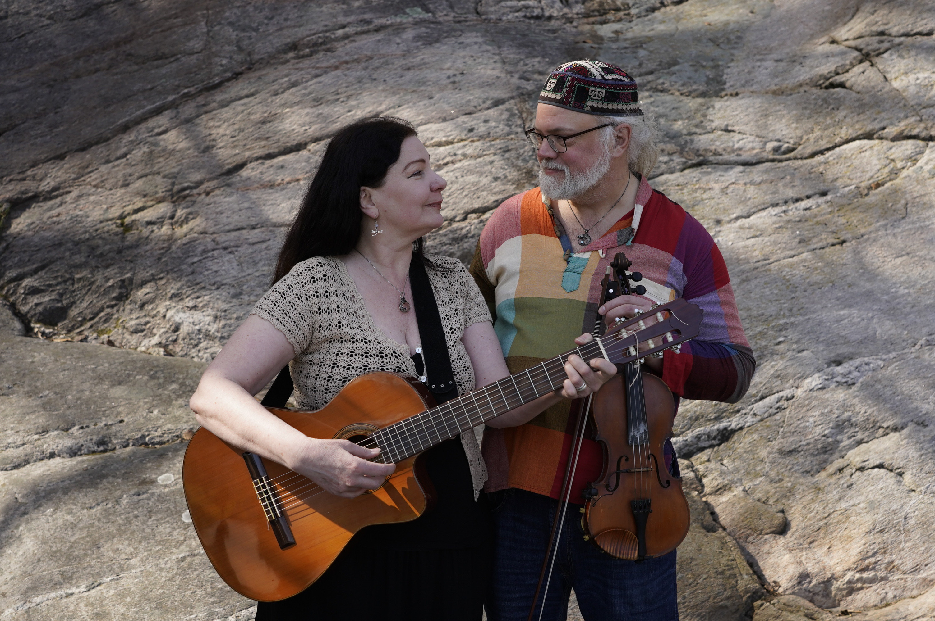 Porträttbild av musikerna Marita Johansson och Jonas Liljeström, från Salamander Duo. Marita håller i en gitarr, Jonas håller i en fiol.