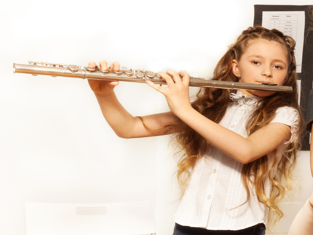 School children playing musical instruments together during their concert in school