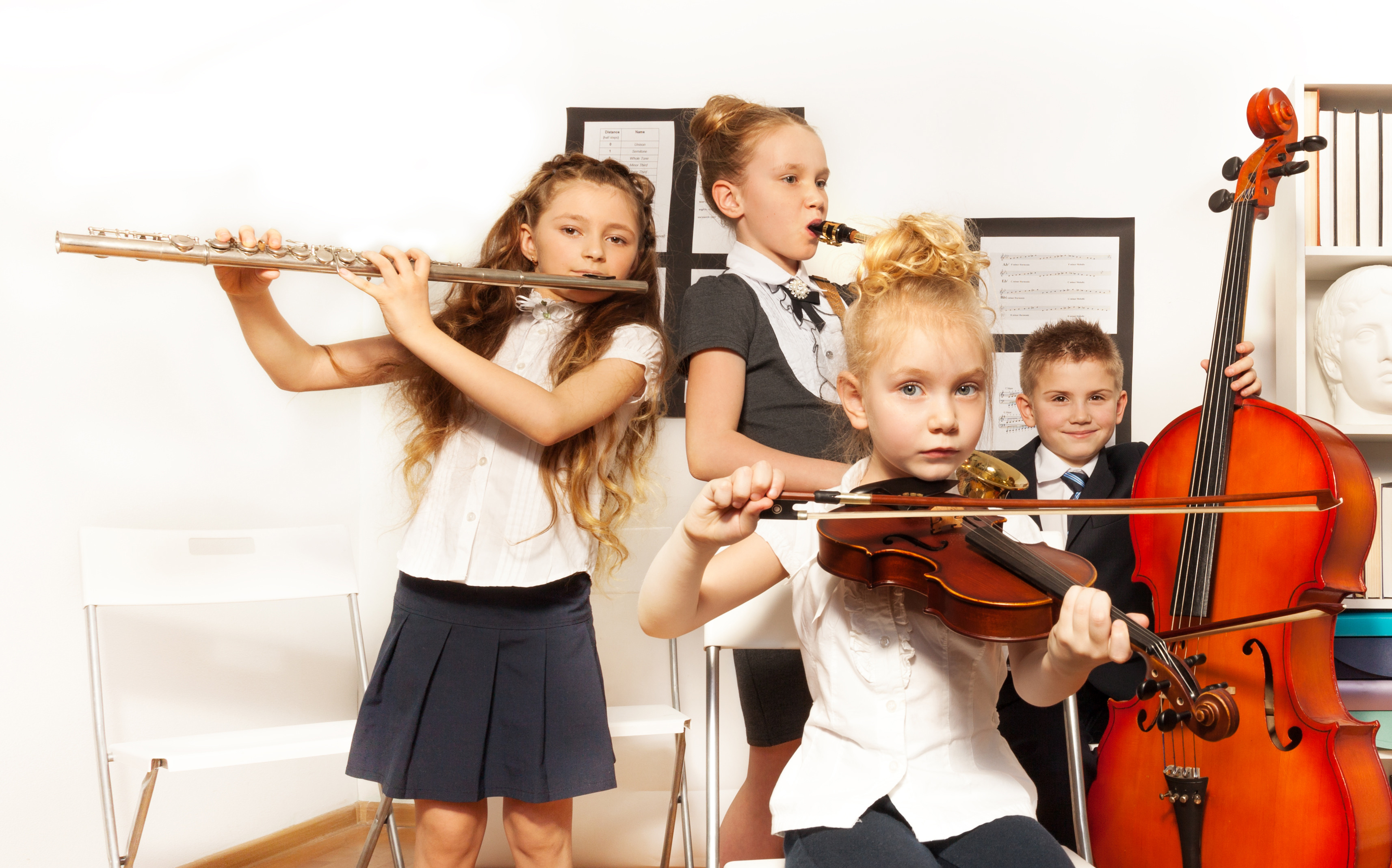 School children playing musical instruments together during their concert in school