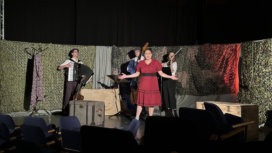 En grupp människor som står på en scen och framför en musikal.