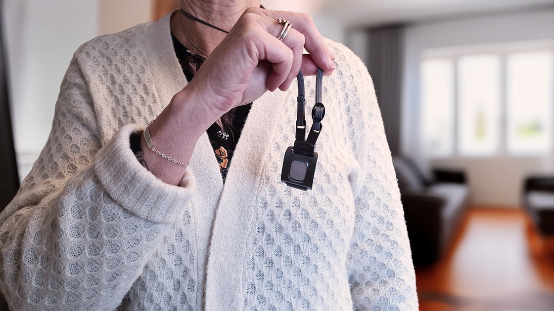 Bilden visar trygghetslarmet hängandes runt halsen i ett band.