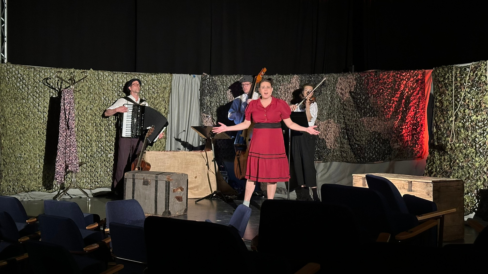 En grupp människor som står på en scen och framför en musikal.