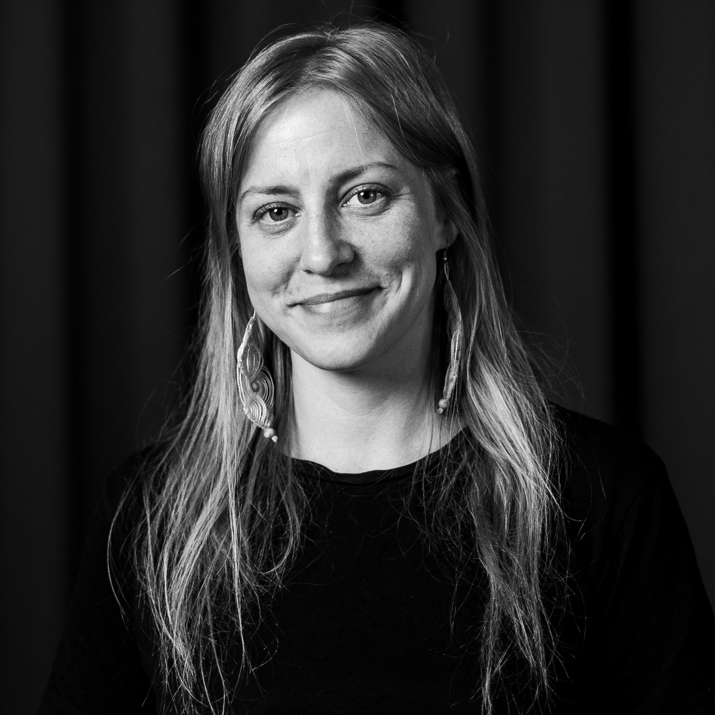 Ett svartvitt foto av en kvinna som ler.