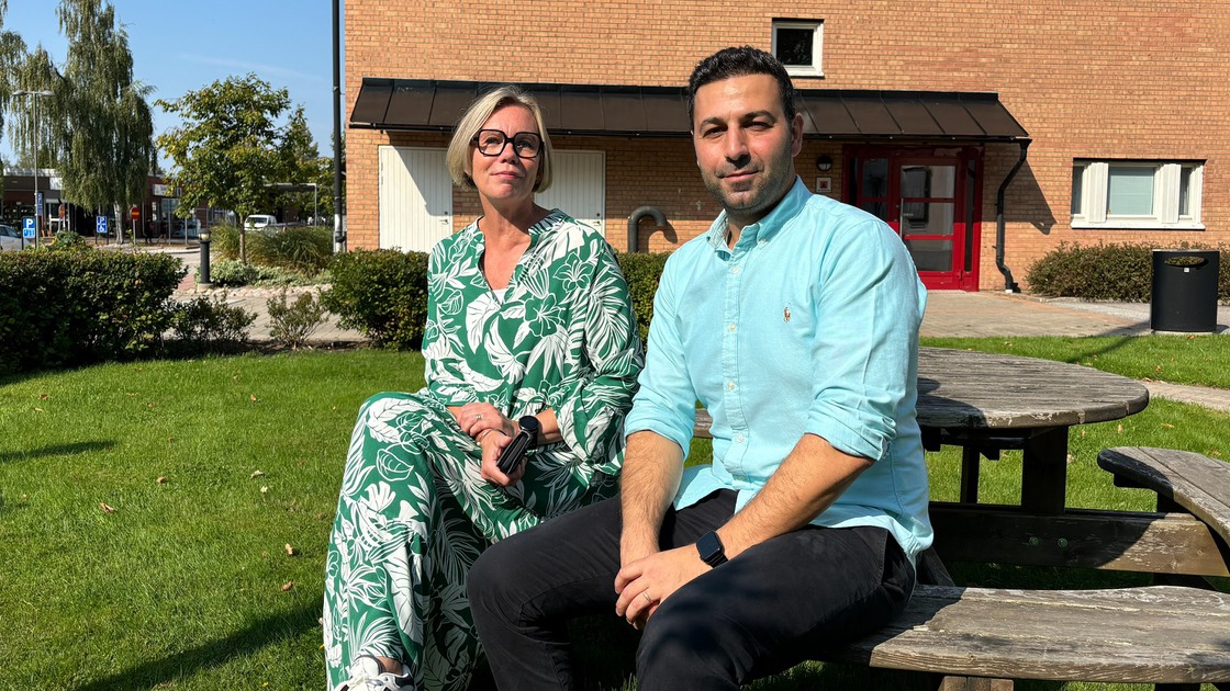 HR-chef Ulrika Wennerkull och kommunalråd Jan Hanna sitter på en bänk framför kommunhuset. 