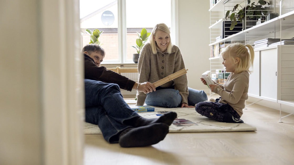 Familj som leker tillsammans i lägenhet.