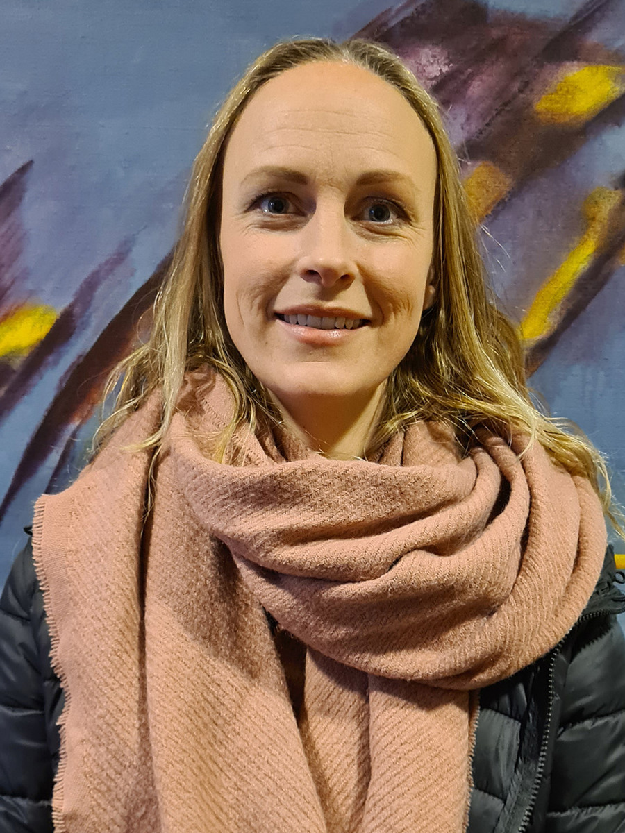 En kvinna står framför en målning.