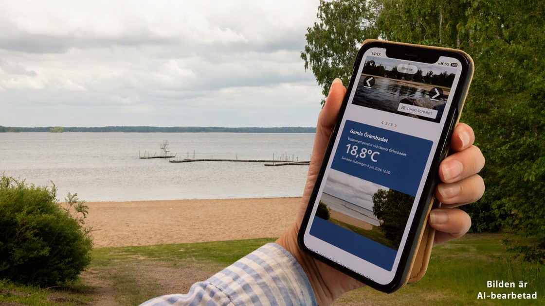 Person håller upp sin mobil med sidan där det går att se vattentemperaturen i sjön Örlen i realtid.