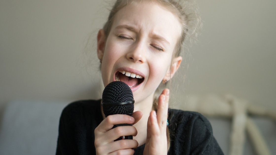 Flicka sjunger karaoke.