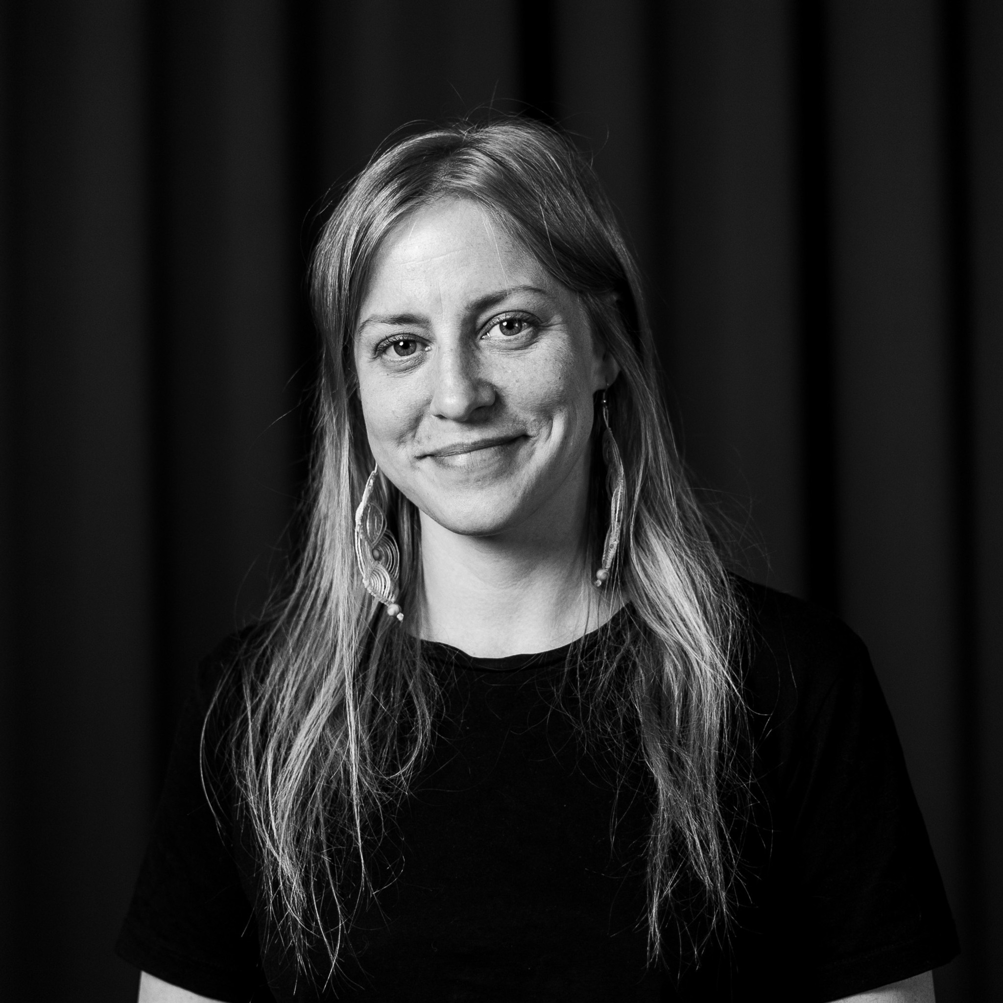 Ett svartvitt foto av en kvinna som ler.