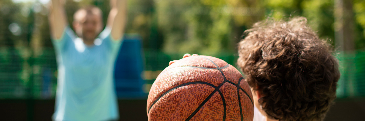 Barn och vuxen spelar basket